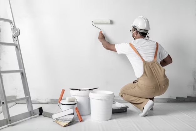 man-paints-white-wall-with-roller